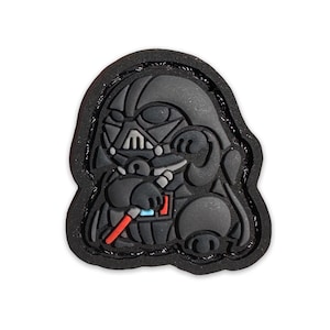 May include: A black and red rubber patch featuring a cartoon Darth Vader character holding a lightsaber.