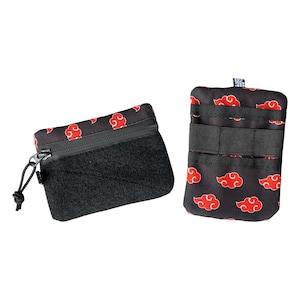 May include: Two black zippered pouches with a red cloud pattern. The pouch on the left has a velcro flap and a zipper closure. The pouch on the right has a zipper closure and three velcro straps.