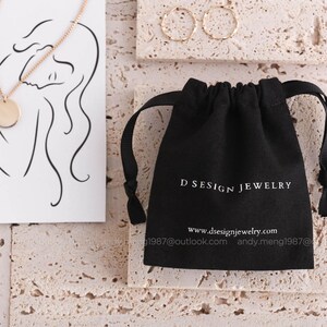 black 8 oz cotton canvas jewelry pouch with white logo