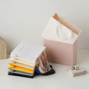 white/ivory/ cream/black paper bags with personalized printing on the front side