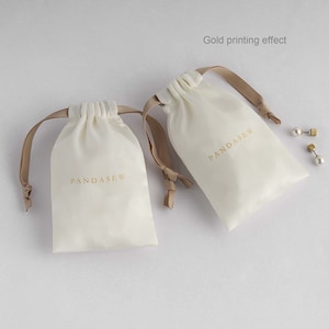 cream white satin bag with gold logo, dusty bag, jewelry package