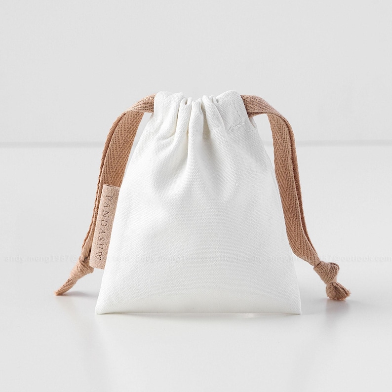 white canvas drawstring bag with label