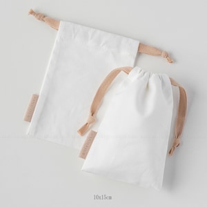white canvas drawstring bag with label