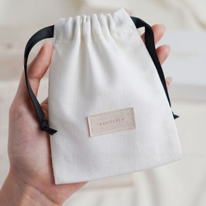 50 pièces pochette d'emballage de bijoux personnalisée avec étiquette sacs en coton sergé logo personnalisé avec ruban petites pochettes sacs pour collier pochette pour boucles d'oreilles