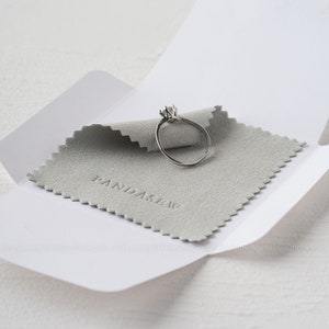 Gray jewelry cleaning cloth to polish rings, necklace and bracelet.