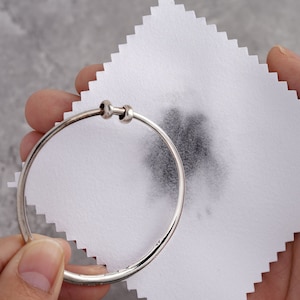 Asilver bracelet was cleaned by treated cloth