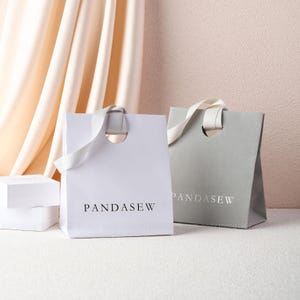 white and gray paper party bags, D shape holes bag