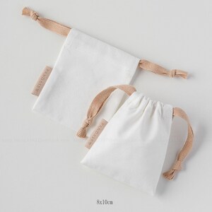 white canvas drawstring bag with label