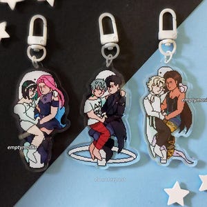 May include: Three acrylic keychains featuring pixel art illustrations of pairs of characters in various outfits. Each charm includes a white plastic lobster clasp. The text "emptymasks" is printed on each charm, and "do not repost" is at the bottom.