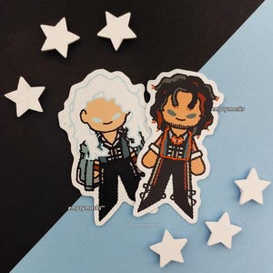 May include: Two pixel art style stickers featuring cartoon characters. One character has long white hair and a blue jacket, while the other has dark hair with red highlights and an orange vest. Both figures have simple facial features and black pants.