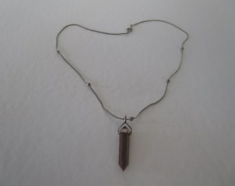 May include: A silver chain necklace with a brown crystal point pendant.