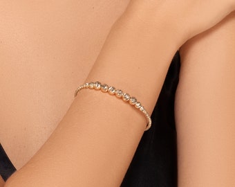 Petra bracelet  - Graduated beaded bangle bracelet in 14 karat solid yellow gold displaying brilliant diamond cut ball beads