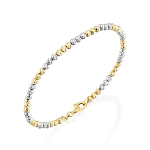 May include: A two-tone gold bracelet with a beaded design. The bracelet is made of both yellow and white gold.
