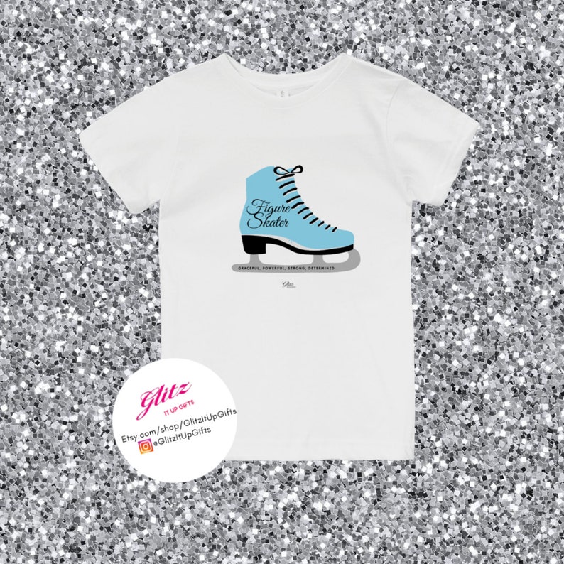 May include: White t-shirt with a blue figure skate graphic and the text "Figure Skater". The text "Graceful, Powerful, Strong, Determined" is printed below the skate. The text "GlitzyUpGifts" is printed on a white circle with a pink outline.
