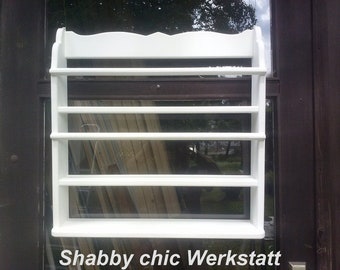 May include: White wooden shelf unit with five shelves. The shelf unit is mounted on a wall and has a decorative scalloped top edge. The text "Shabby chic Werkstatt" is visible at the bottom of the image.