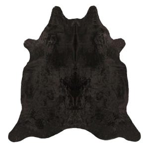 May include: Black cowhide rug with a natural, shaggy texture. The hide is large and has a natural, organic shape.