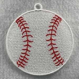 May include: White and red embroidered baseball ornament. The ornament is round and has red stitching on a white background.