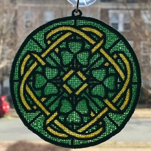 May include: A green and yellow circular window cling with a Celtic knot design featuring four shamrocks.