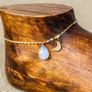 Peut inclure: Chevillère dorée avec un pendentif en pierre de lune en forme de larme et un pendentif en forme de croissant de lune.