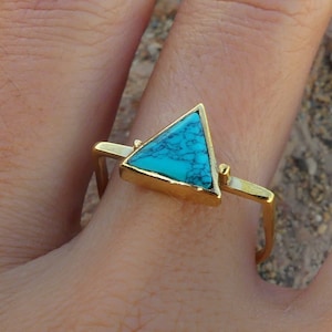 Peut inclure: Une bague en or avec une pierre turquoise en forme de triangle.