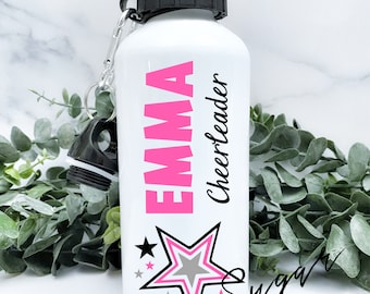 Könnte beinhalten: Eine weiße Wasserflasche mit einem pinkfarbenen und schwarzen Sternendesign. Der Name "Emma" und der Text "Cheerleader" sind in Pink auf die Flasche gedruckt. Die Worte "Sugar + Faith" sind in schwarzer Kursivschrift unten rechts auf der Flasche geschrieben.