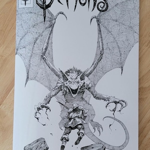 May include: Comic book cover featuring a detailed black and white illustration of a demon with large wings and a long tail. The word "DEMONS" is prominently displayed in a stylized font. The number "22" is in a circle in the upper left corner.