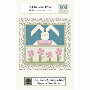 Może przedstawiać: Wzór do szycia kołdry o wymiarach 79 cm x 79 cm przedstawiający białego królika z różowymi uszami i różowo-biały ogródek kwiatowy. Wzór nosi tytuł "#446 Rosie Posie" i został zaprojektowany przez Cheryl Haynes dla The Prairie Grove Peddler.