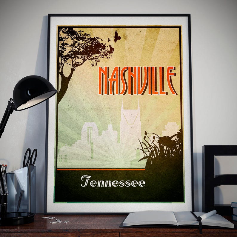 May include: Framed poster of Nashville, Tennessee, with a vintage travel design. The poster features the city's name in orange, a skyline silhouette, and the word "Tennessee" below. A tree and birds are also depicted.