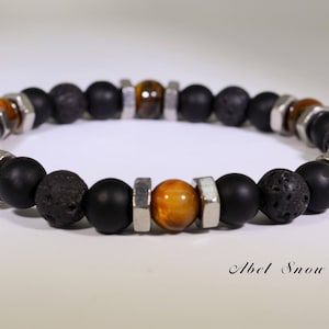 May include: A beaded bracelet featuring black matte onyx, lava rock, and tiger's eye beads. The bracelet is accented with silver-colored metal hardware. The bracelet is a stylish accessory.