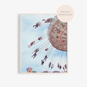 May include: A vintage-style carnival ride with people swinging high in the air against a blue sky. The ride has a colorful, painted canopy with intricate details.