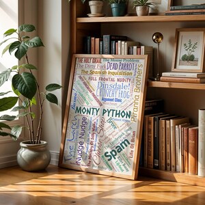 May include: A wooden framed print with a word cloud design, featuring phrases from Monty Python. The print is displayed on a wooden bookshelf. The text includes "The Holy Grail", "Spam", and "Crunchy Frog".