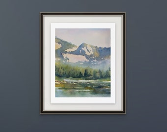 May include: A framed watercolor painting of a mountain landscape with a lake in the foreground. The mountains are painted in shades of blue and green, and the lake is a light blue. The painting is framed in a black frame.