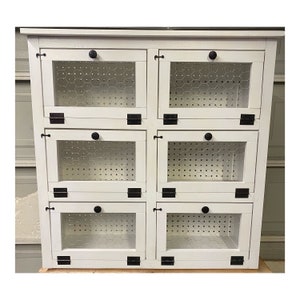 May include: White wooden cabinet with six compartments, each with a wire mesh door and black metal hinges and knobs.