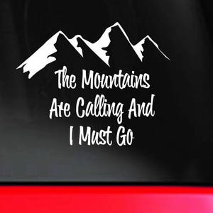 Może przedstawiać: Biała naklejka winylowa z sylwetką gór i tekstem "The Mountains Are Calling And I Must Go".