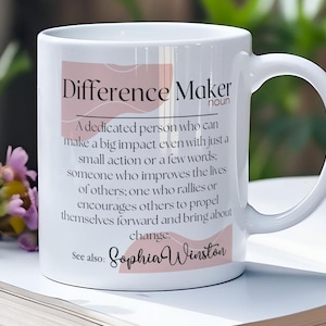 May include: White ceramic coffee mug with a pink and white design. The mug features the text "Difference Maker" with a definition and the name "Sophia Winston".