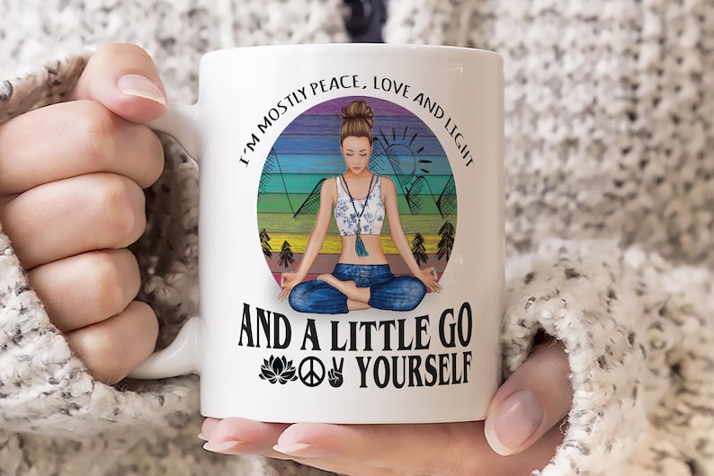 May include: White ceramic mug with a colorful illustration of a woman meditating in a circle with the text "I'm mostly peace, love and light and a little go yourself" with a peace sign and a lotus flower.