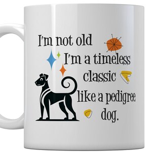 May include: White ceramic mug with a black and white dog illustration and the text "I'm not old, I'm a timeless classic like a pedigree dog." The mug has a curved handle and decorative starbursts.
