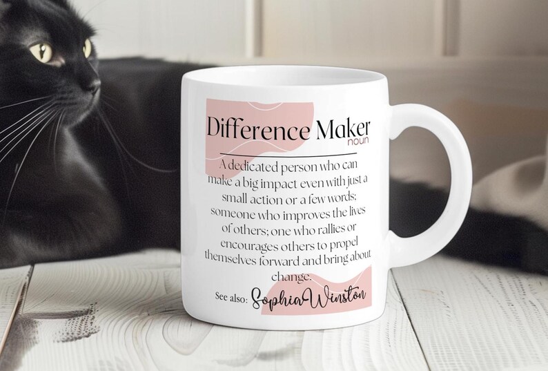 May include: White ceramic mug with a pink and white design. The mug has the text "Difference Maker" with a definition and the name "Sophia Winston".