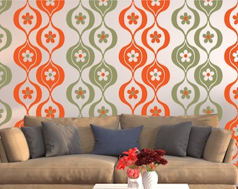 May include: A brown couch with pillows in front of a wall with a retro pattern of orange and green teardrop shapes with white flowers.