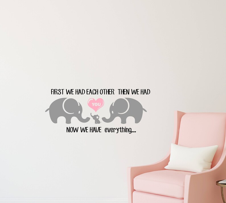 Pu&ograve; includere: Un adesivo da parete con una famiglia di elefanti grigi con il testo "First we had each other, then we had you. Now we have everything..." Gli elefanti tengono un cuore rosa con la parola "you" all'interno.