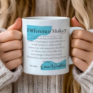 May include: White ceramic mug with a blue and white design. The mug features the text "Difference Maker" with a definition and the name "Liam Winston".