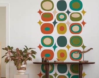 Può includere: Un muro bianco con un motivo geometrico di cerchi turchesi, arancioni, verdi e beige. I cerchi sono disposti a griglia e sono circondati da stelle bianche. Davanti al muro c'è un tavolo da console in legno con piano marrone e gambe nere.