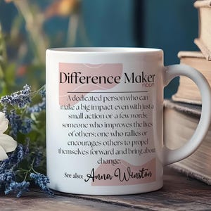 May include: White ceramic mug with a pink and white design. The mug features the text "Difference Maker" with a definition and the name "Anna Winston".