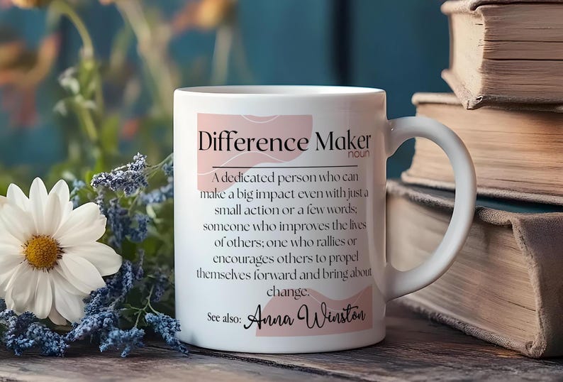 May include: White ceramic mug with a pink and white design. The mug features the text "Difference Maker" with a definition and the name "Anna Winston".