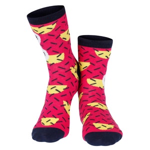May include: A pair of red socks with a geometric pattern of yellow and black shapes. The socks have a navy blue cuff.