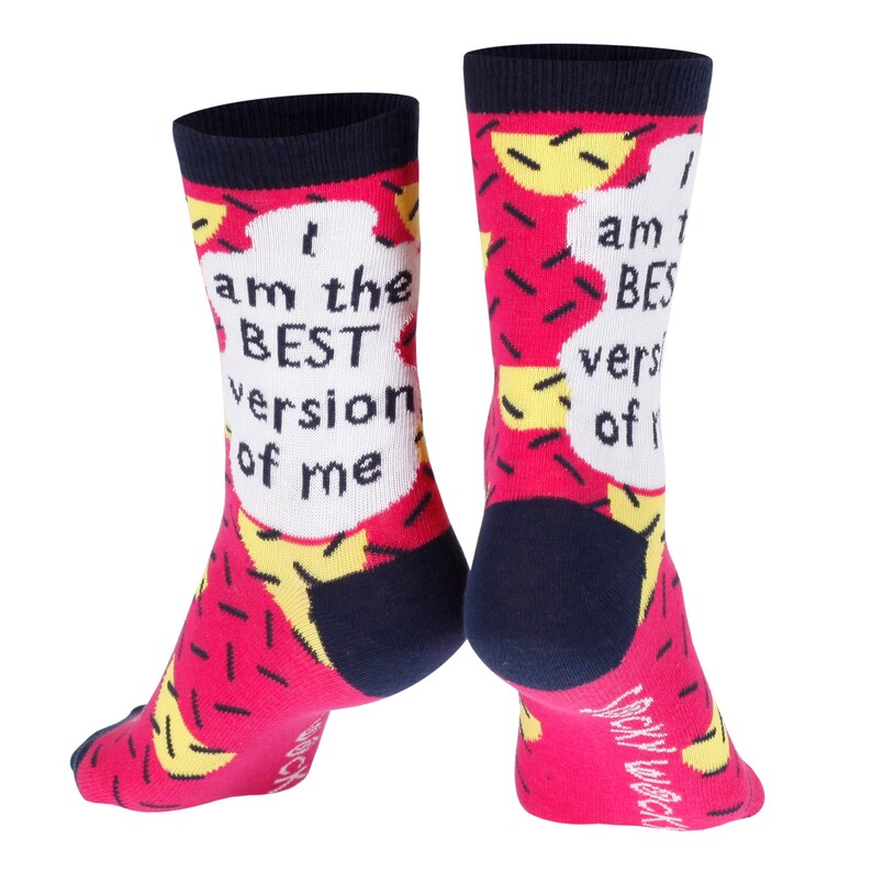 May include: A pair of pink and black socks with a white speech bubble on each sock. The speech bubble on the left sock says "I am the BEST version of me". The speech bubble on the right sock says "I am the BEST version of me".