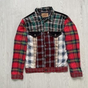 May include: A patchwork denim jacket with a variety of plaid patterns in red, green, and blue. The jacket has a black collar and pockets, and a brown label on the back of the neck.