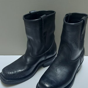 May include: A pair of black leather ankle boots with a pointed toe and a slight heel. The boots have a textured, pebbled surface.