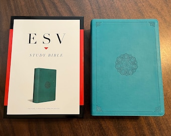 Könnte beinhalten: Eine gebundene Studienbibel in Türkisblau mit dem Text "ESV Study Bible" auf dem vorderen Umschlag. Die Bibel ist geschlossen und liegt auf einer Holzoberfläche.