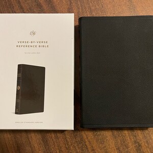 May include: A black leather-bound Bible with the title "Verse-by-Verse Reference Bible" and the text "English Standard Version" on the cover.